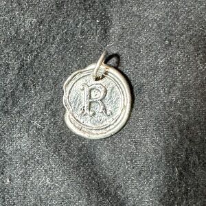 Waxing poetic charm. Silver The letter R.